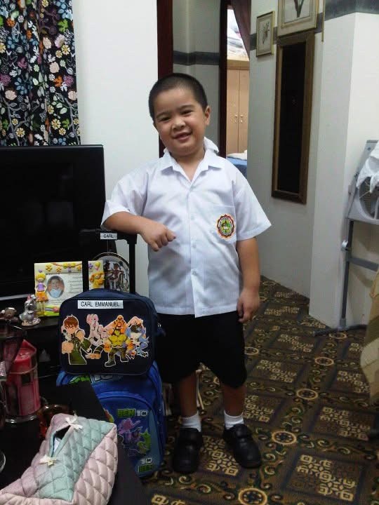 Young Carl in his school uniform, next to his Ben 10 school bag